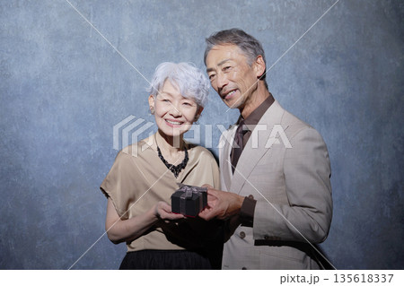 プレゼントを持つシニア夫婦 ポートレート プレゼントを持つシニア夫婦 ポートレート 135618337