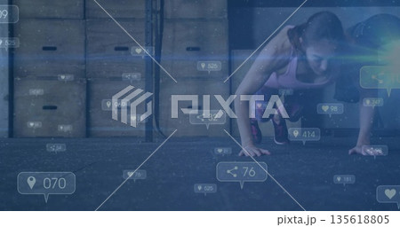 Sportswear-clad woman doing push-ups on rubber gym floor with plyo boxes, overlay icons, copy space 135618805
