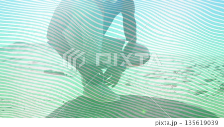 Kneeling shirtless man in shorts gazing across rippled sand dune under bright sun, with lens flare Kneeling shirtless man in shorts gazing across rippled sand dune under bright sun, with lens flare 135619039