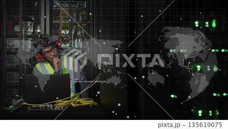 Leaning IT technician in safety vest, earmuffs inspecting laptop cables in server room, copy space Leaning IT technician in safety vest, earmuffs inspecting laptop cables in server room, copy space 135619075