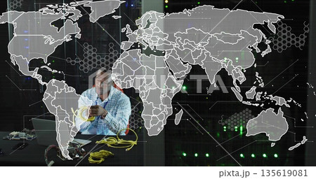 Technician in checkered shirt handling yellow Ethernet cables in tech lab, with laptop, copy space 135619081