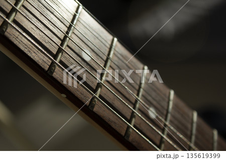 This is a close-up of the strings of an acoustic guitar. 135619399