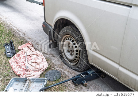 Flat Tire Emergency Car Jacked Up for Repair on Roadside, Changing Wheel, Car Breakdown Flat Tire Emergency Car Jacked Up for Repair on Roadside, Changing Wheel, Car Breakdown 135619577