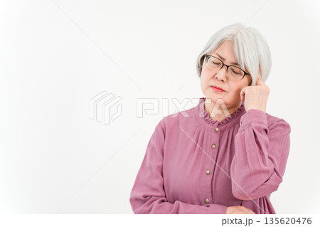 グレイヘア,シルバーヘアのシニア女性(悩み,悩む,困る,考える,吟味,頭痛) グレイヘア,シルバーヘアのシニア女性(悩み,悩む,困る,考える,吟味,頭痛) 135620476