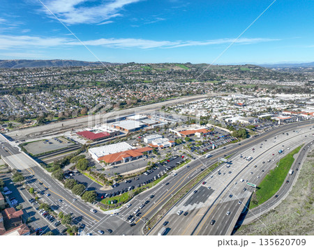 Aerial view over San Juan Capistrano, California, featuring the historic mission, library, sports courts, and an Amtrak train pulling into the downtown station. Aerial view over San Juan Capistrano, California, featuring the historic mission, library, sports courts, and an Amtrak train pulling into the downtown station. 135620709