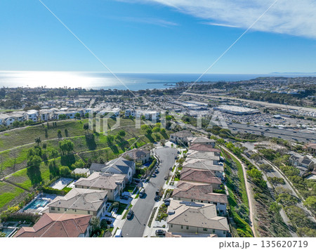Aerial view over San Juan Capistrano, California, featuring the historic mission, library, sports courts, and an Amtrak train pulling into the downtown station. Aerial view over San Juan Capistrano, California, featuring the historic mission, library, sports courts, and an Amtrak train pulling into the downtown station. 135620719