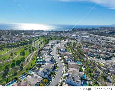 Aerial view over San Juan Capistrano, California, featuring the historic mission, library, sports courts, and an Amtrak train pulling into the downtown station. 135620724