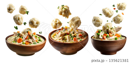 Hearty chicken and dumplings soup with peas and carrots in wooden bowl, floating dumplings, isolated on white background 135621381