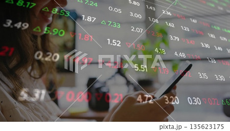 Woman reviewing floating financial overlays on smartphone at home office, with camera, copy space Woman reviewing floating financial overlays on smartphone at home office, with camera, copy space 135623175