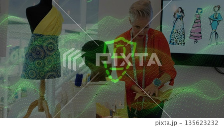Collaborating two women sewing garment in fashion design studio, with dress form and sewing machine 135623232