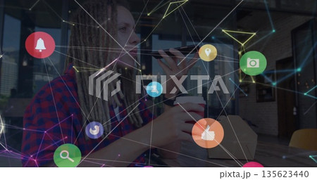 Sitting man in checkered shirt holding smartphone and coffee cup at cafe, with social media icons 135623440