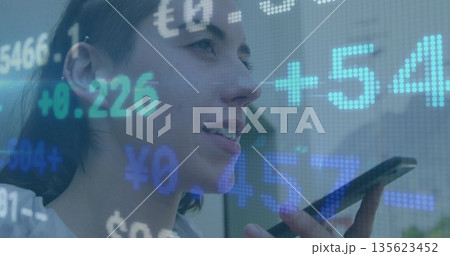 Speaking woman in casual top holding smartphone near mouth in office, with financial data overlays 135623452