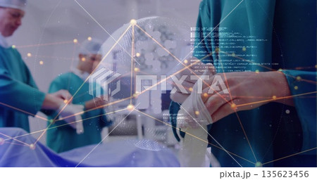 Male surgeon pulling sterile gloves on over gown in operating room, with digital globe, copy space Male surgeon pulling sterile gloves on over gown in operating room, with digital globe, copy space 135623456