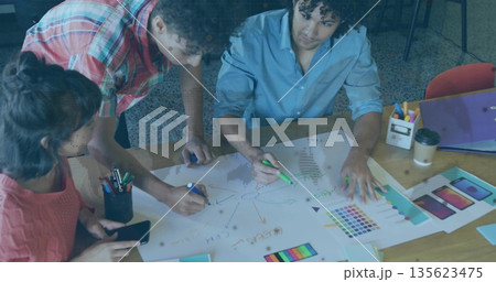 Three colleagues sketching diagrams on paper in studio, with colored markers and swatch charts Three colleagues sketching diagrams on paper in studio, with colored markers and swatch charts 135623475