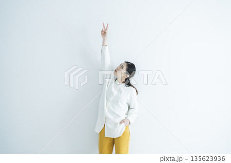 ピースサインをするメガネをかけた女性 135623936