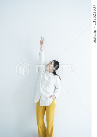 ピースサインをするメガネをかけた女性 135623937