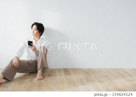 床に座る男性 床に座る男性 135624124