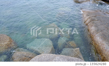 Crystal Clear Sea Water Washing Over Granite Rocks at Siangau Beach Coastline Bangka Belitung 135624280