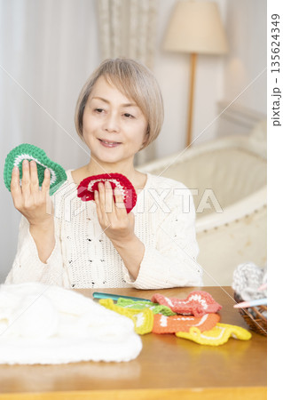 リビングで毛糸のアクリルたわしを編むシニア女性 リビングで毛糸のアクリルたわしを編むシニア女性 135624349