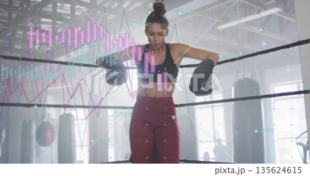 Leaning boxer wearing black sports bra, leggings, breathing in boxing ring with gloves data overlay Leaning boxer wearing black sports bra, leggings, breathing in boxing ring with gloves data overlay 135624615