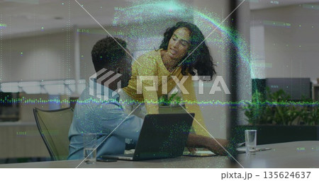 Discussing coworkers wearing colorful attire at office desk, with laptop, water glasses, overlay Discussing coworkers wearing colorful attire at office desk, with laptop, water glasses, overlay 135624637