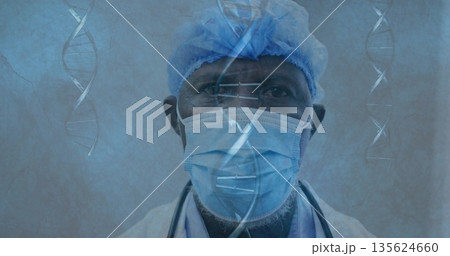Male doctor studying floating DNA strands in lab, wearing surgical cap, face mask and stethoscope Male doctor studying floating DNA strands in lab, wearing surgical cap, face mask and stethoscope 135624660