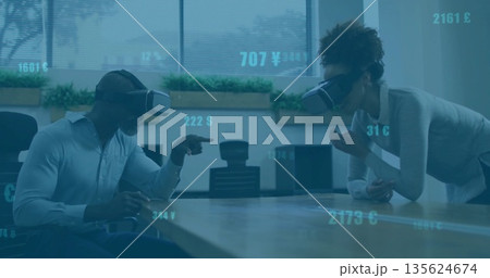 Interacting coworkers simulating currency data in corporate conference room, wearing VR headsets 135624674