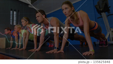 Performing push-ups workout group holding high plank on raised platform in gym, with graph overlay 135625848