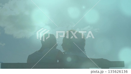 Leaning couple sharing moment on overlook wooden bench showing backlit silhouettes and lens flares Leaning couple sharing moment on overlook wooden bench showing backlit silhouettes and lens flares 135626136