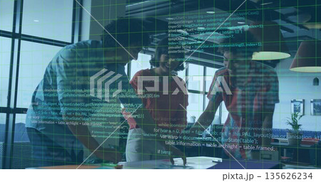 Collaborating professionals leaning over table in sunlit office, with laptops tablet documents Collaborating professionals leaning over table in sunlit office, with laptops tablet documents 135626234
