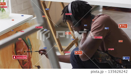 Painting painter wearing headphones applying paint on canvas in studio, with icons, copy space Painting painter wearing headphones applying paint on canvas in studio, with icons, copy space 135626242