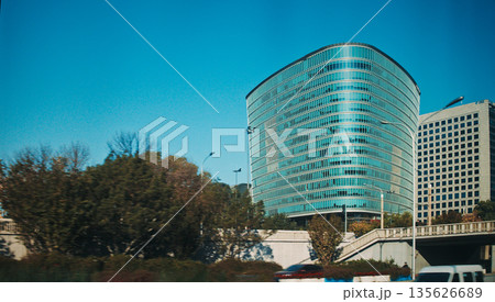 Contemporary cylindrical building with horizontal stripes in Beijing park area during autumn season Contemporary cylindrical building with horizontal stripes in Beijing park area during autumn season 135626689