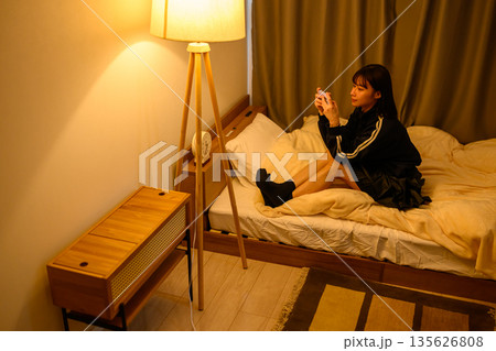 寝室でゲームをする女子高生 135626808