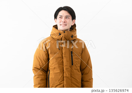 ダウンコートを着ている若い男性 135626974