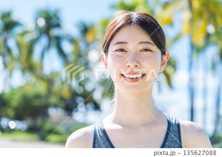 リゾート地でジョギングをする若い女性 135627088