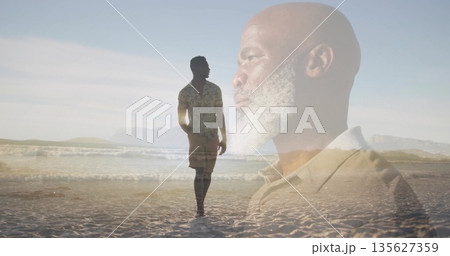 Walking man wearing patterned shirt on sandy shoreline, with father in light-colored polo overlay Walking man wearing patterned shirt on sandy shoreline, with father in light-colored polo overlay 135627359