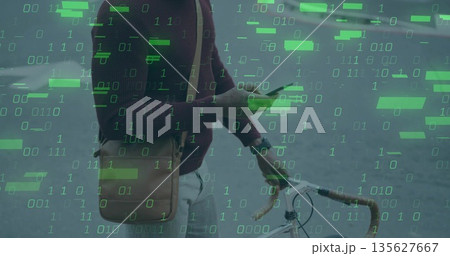 Standing man holding smartphone and gripping bike handlebar on city street, with binary digits Standing man holding smartphone and gripping bike handlebar on city street, with binary digits 135627667