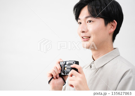 フィルムカメラを持っている若い男性 135627863