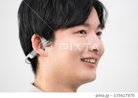 ワイヤレスイヤホンで音楽を聴く若い男性 ワイヤレスイヤホンで音楽を聴く若い男性 135627870