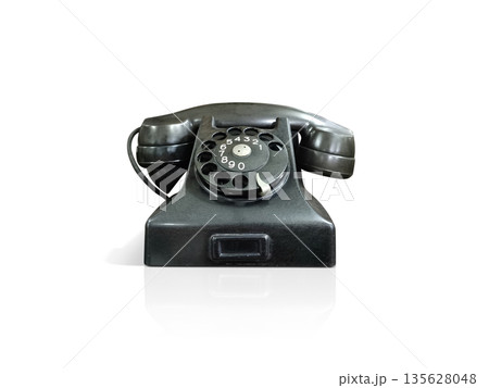 An old black desktop telephone on a white background. An old black desktop telephone on a white background. 135628048