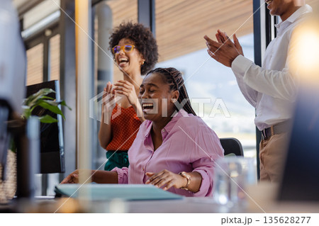 African American woman laughing with colleagues in office during successful meeting African American woman laughing with colleagues in office during successful meeting 135628277