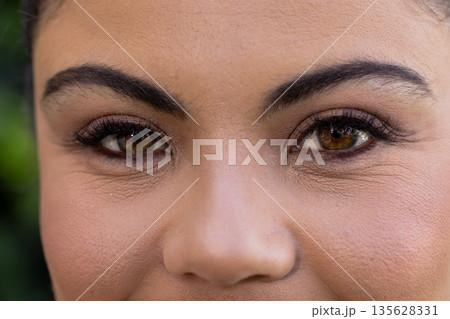 Close-up of woman's eyes with natural makeup, showcasing beauty and elegance 135628331