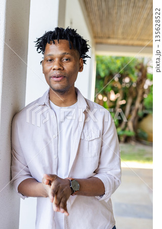 Smiling man in casual shirt standing outdoors, enjoying sunny day 135628522