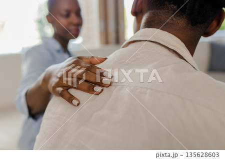 Offering support, African American woman gently comforting friend at home 135628603