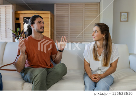 Friends talking on sofa at home, sharing stories and enjoying conversation Friends talking on sofa at home, sharing stories and enjoying conversation 135628610