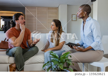 In school, diverse friends discussing ideas, woman holding tablet, engaged conversation In school, diverse friends discussing ideas, woman holding tablet, engaged conversation 135628621