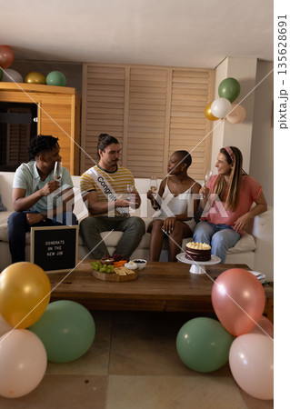 Celebrating new job, diverse friends enjoying drinks and cake at home party 135628691