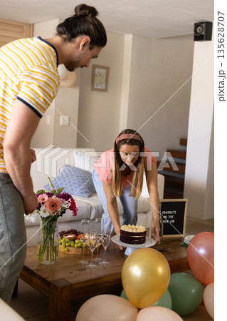 Celebrating new job, friends arranging cake and drinks in living room 135628707