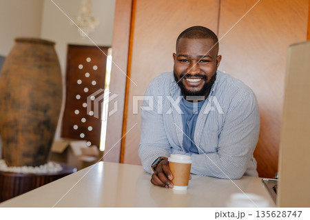 Smiling man enjoying coffee at home, leaning on kitchen counter Smiling man enjoying coffee at home, leaning on kitchen counter 135628747