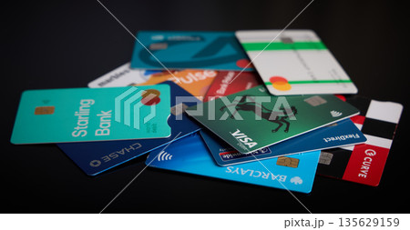 Scattered Credit and Debit Cards on Dark Background 135629159